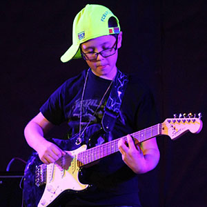 Photo of a student playing guitar during an event.