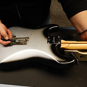 Photo of someone repairing a guitar.