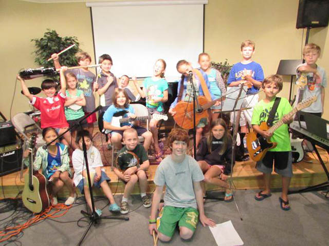 A photo of all students participating in a summer camp on stage.