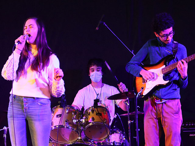 A photo of a student band performing on stage during an event.