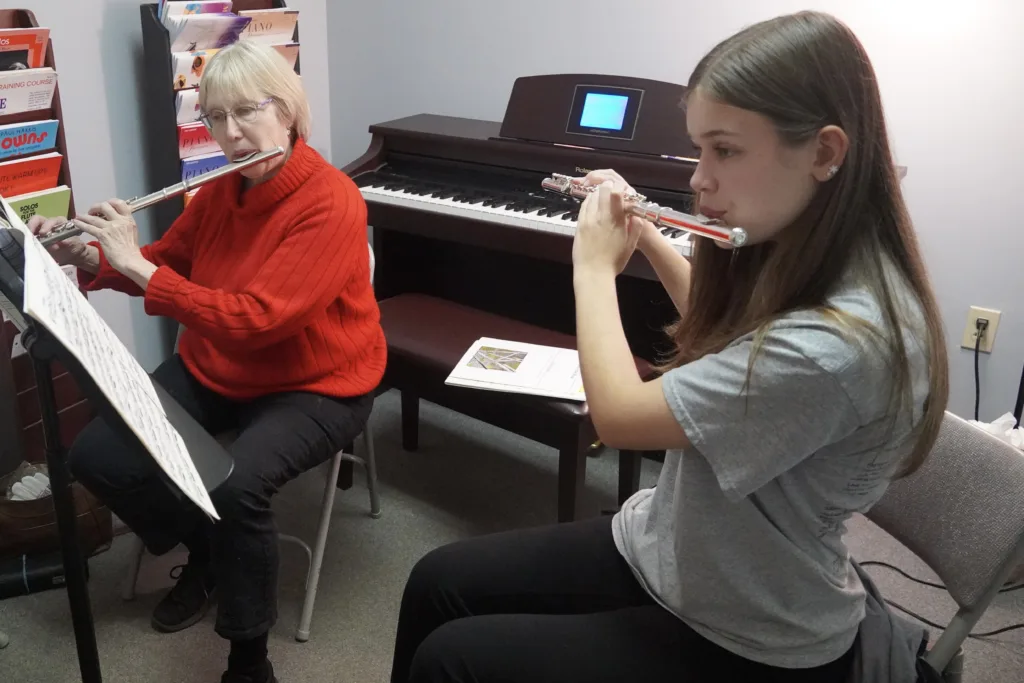 Photo of a flute student and their teacher practicing.
