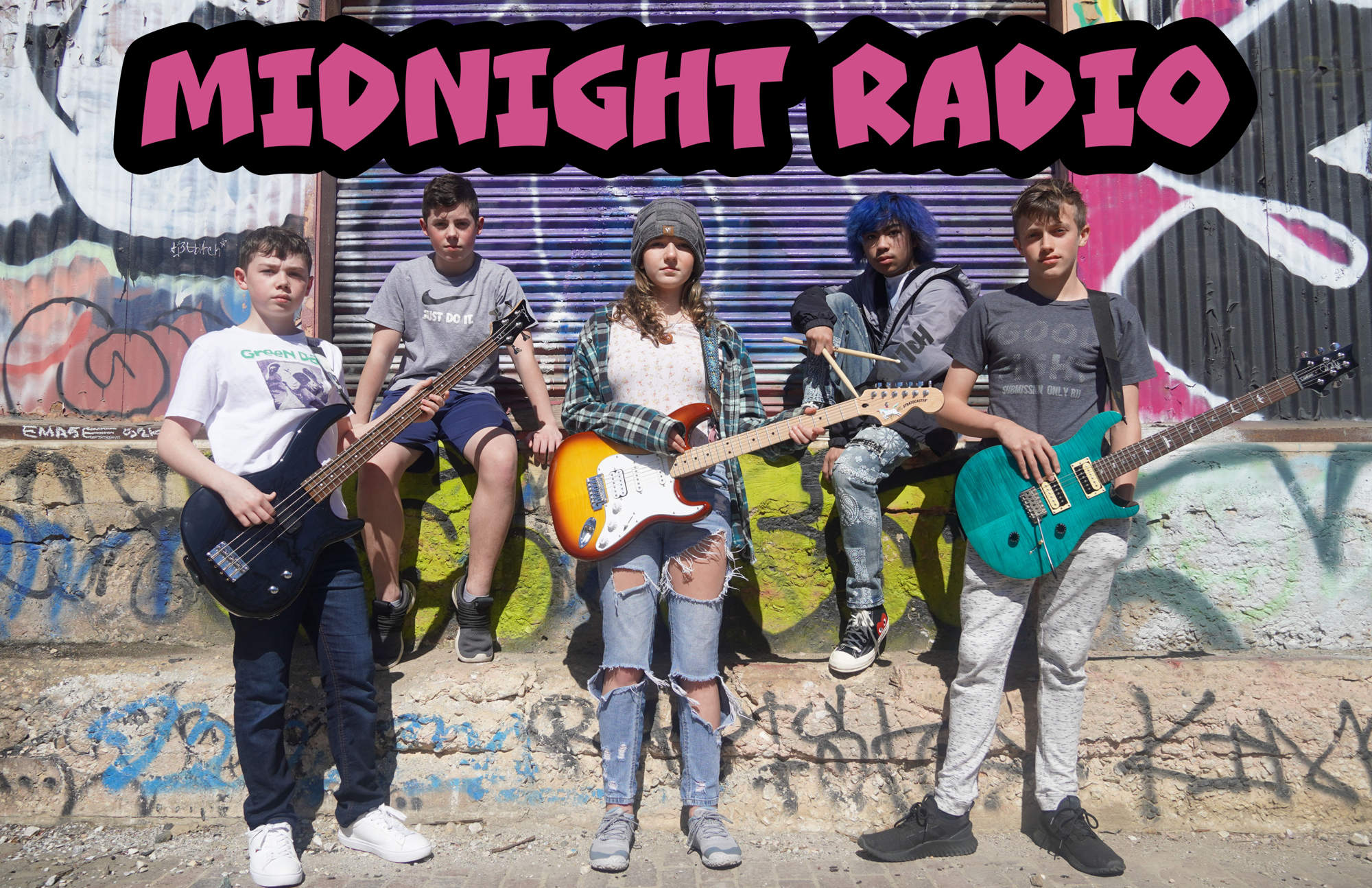 A student band posing with their instruments with the words "Midnight Radio" across the top.