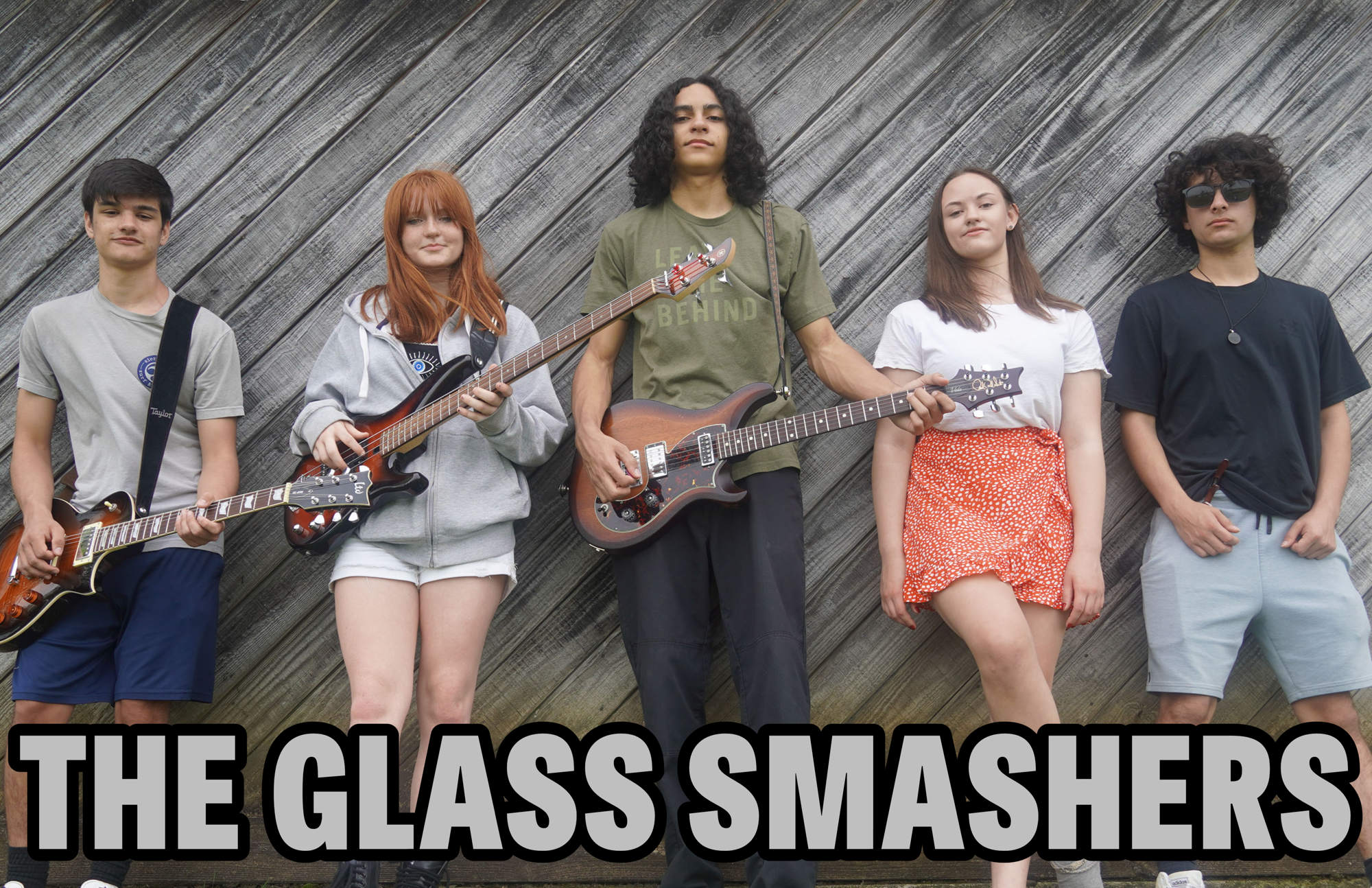 A student band posing with their instruments with the words "The Glass Smashers" across the bottom.