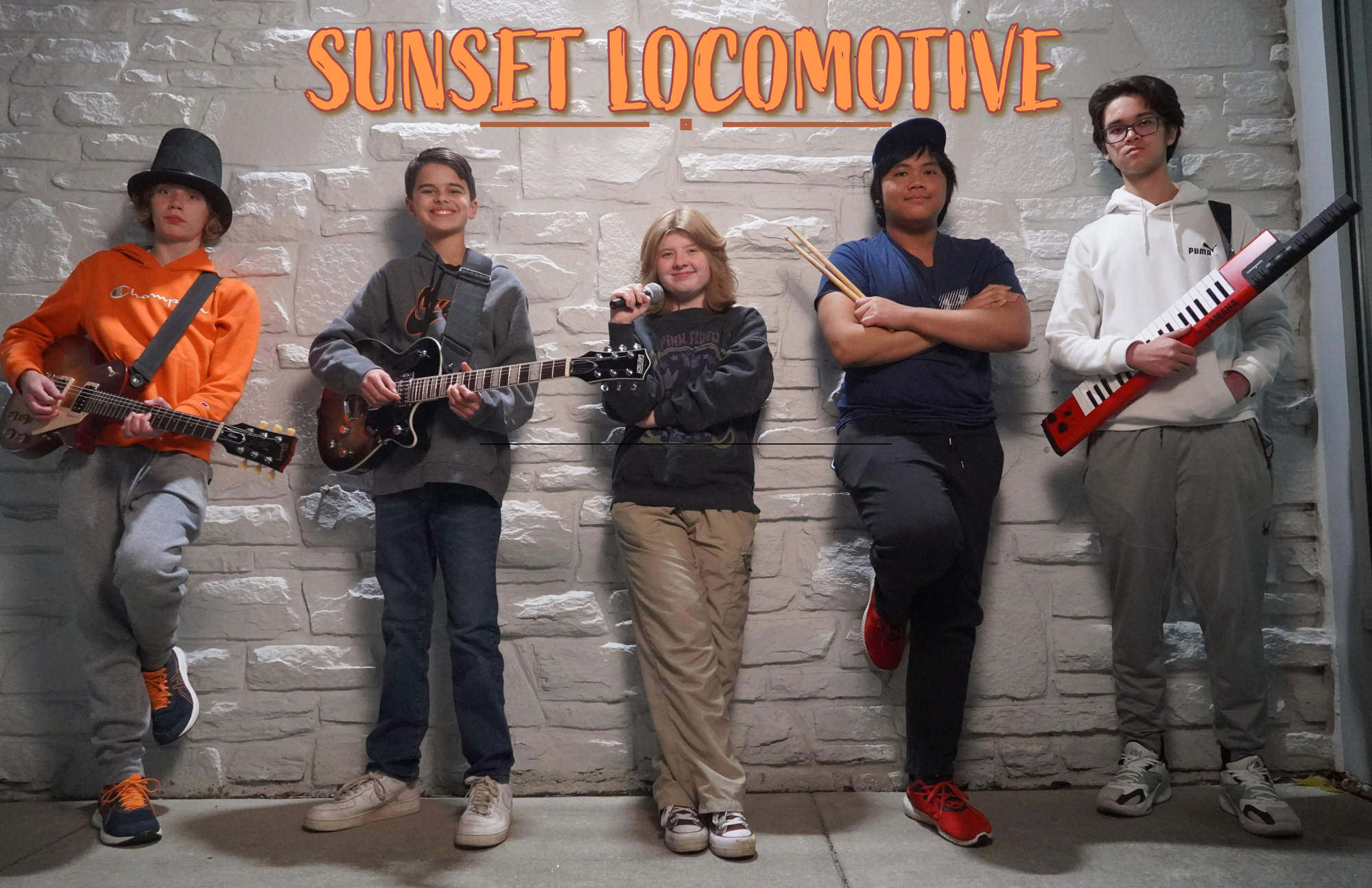 A student band posing with their instruments with the words "Sunset Locomotive" across the top.