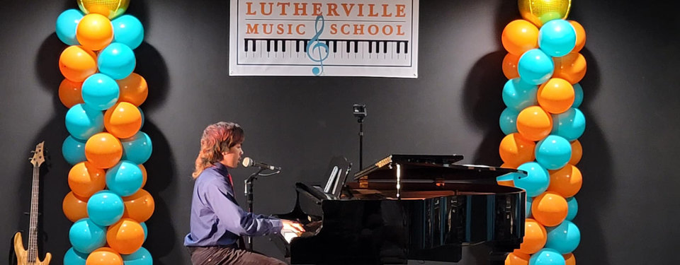 A student performing at the Recital Hall on a grand piano.