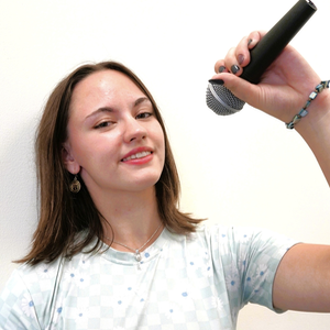 A photo of Abby Marinari holding a microphone.