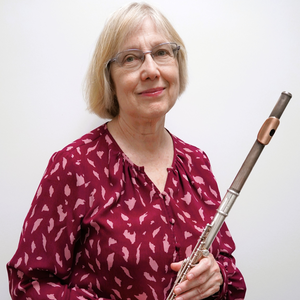 A photo of Janet Muller holding a flute.