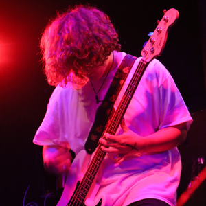 A photo of Nathaniel Holler playing bass live on stage.