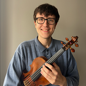 A photo of Elias holding a violin.