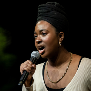 A photo of Ellis Mensah singing into a microphone.
