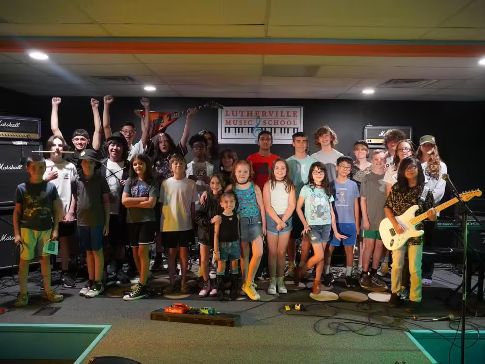 A photo of a group of students posing at a rock summer camp.