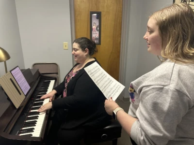 Voice and Singing Photo of a student singing while their teacher accompanies them on the piano.
