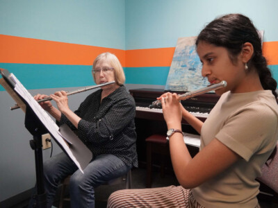 Woodwinds Photo of a flute student and their teacher practicing.